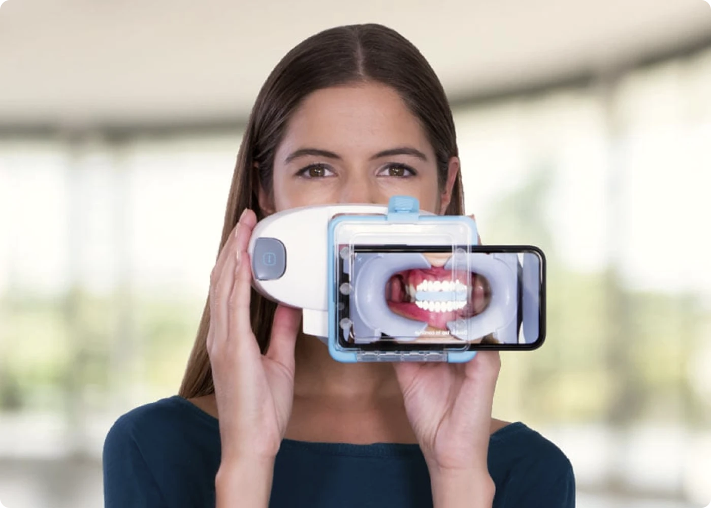 Patiente qui photographie ses dents avec son téléphone et une ScanBox